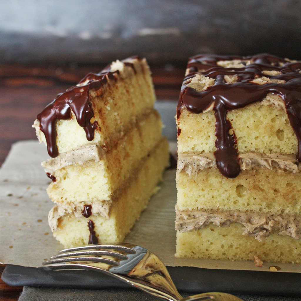 Sliced opera cake showing layers of sponge and coffee buttercream under a dark chocolate glaze.