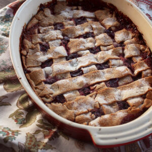 Texas dewberry cobbler with a lattice crust dusted in sugar, bubbling purple fruit beneath.